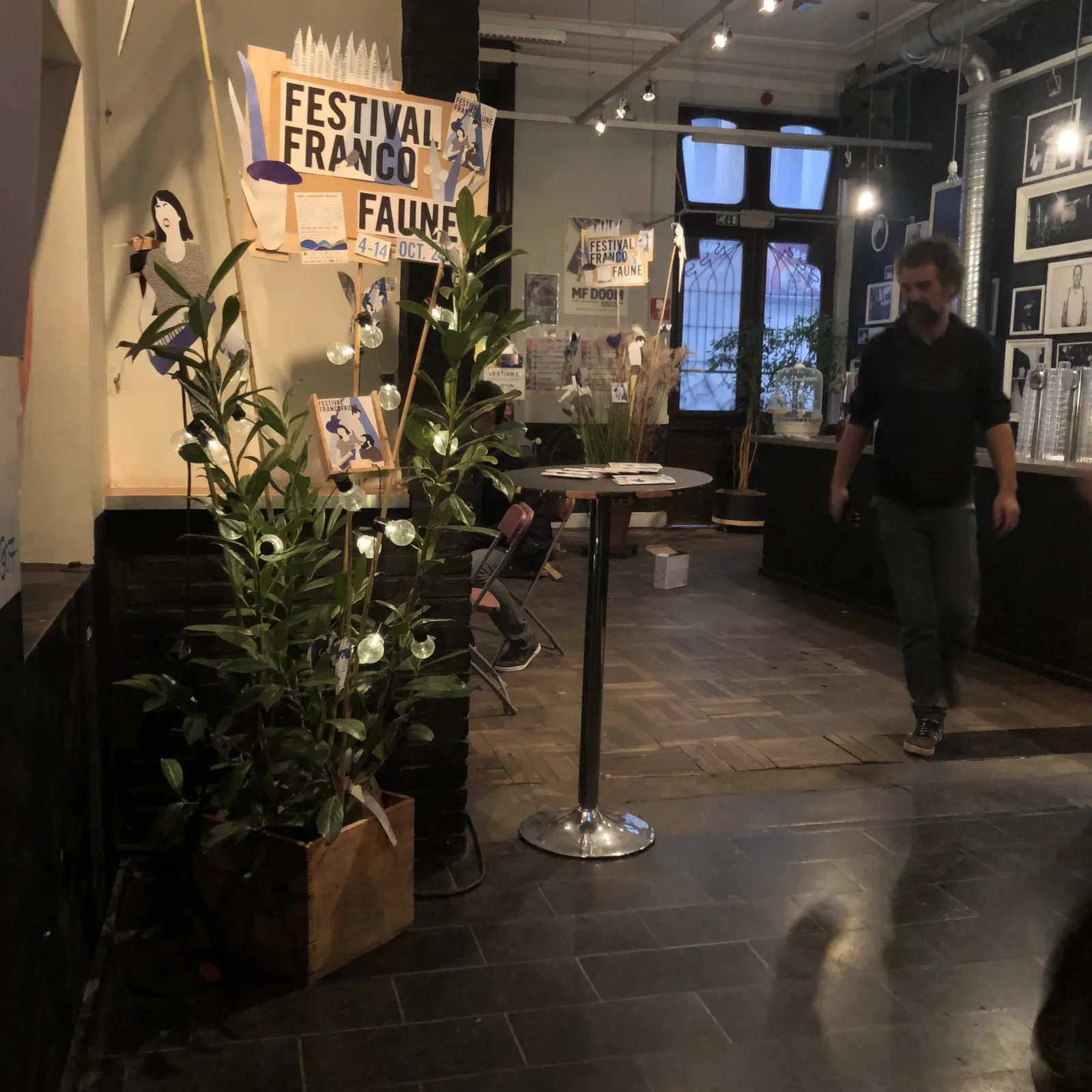 Le totem FRANCO FAUNE dressé contre un mur de briques blanches, dans une cour