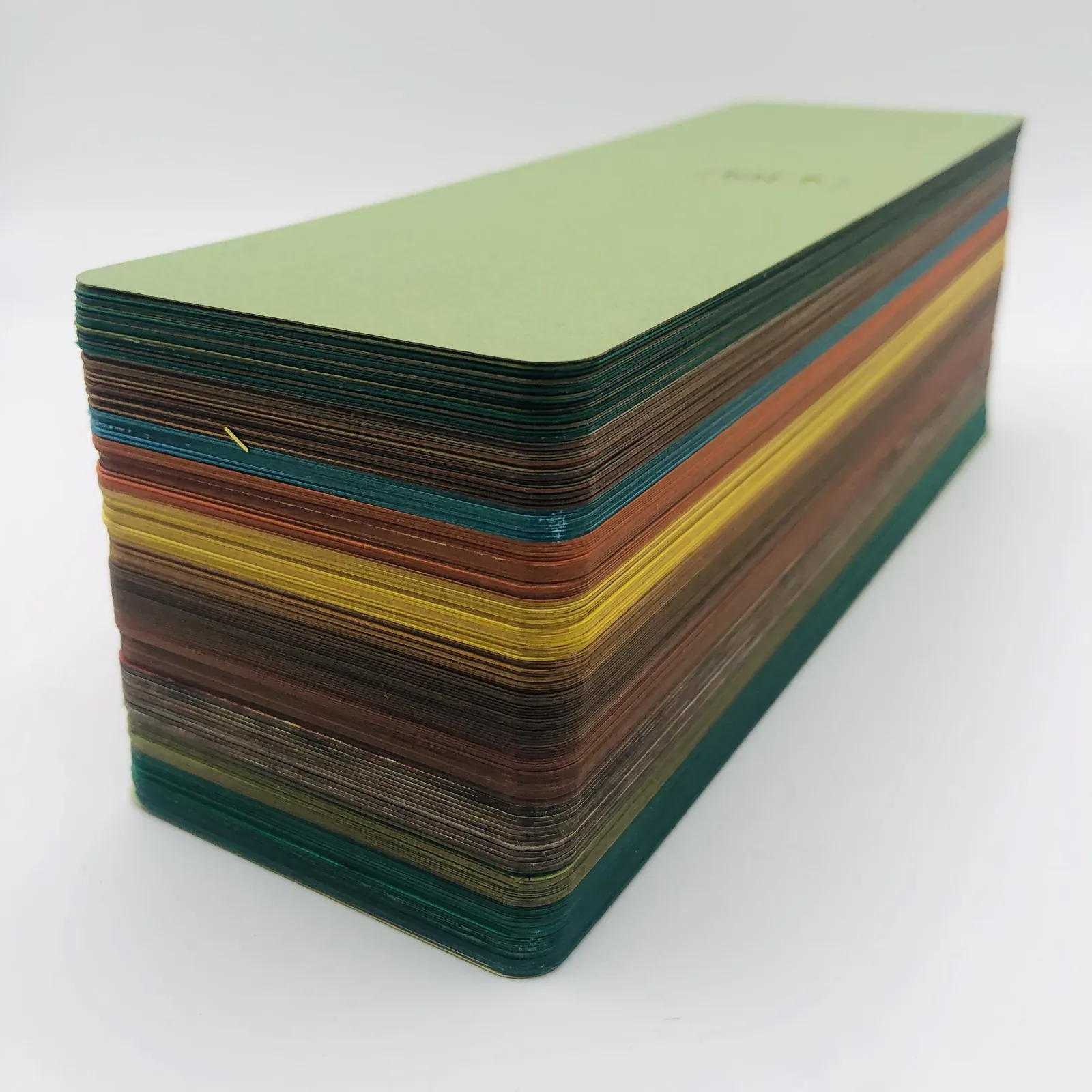 Le lot vu par la tranche : une trentaine de marque-pages empilés, chaque papier donnant sa ligne de couleur