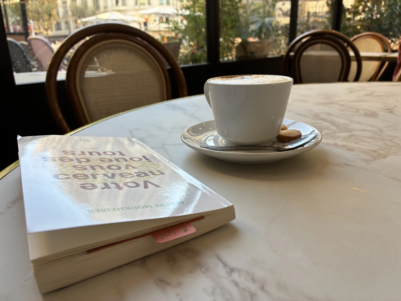 En usage : le marque-page dépasse d’un livre posé sur une table de café, à côté d’une tasse