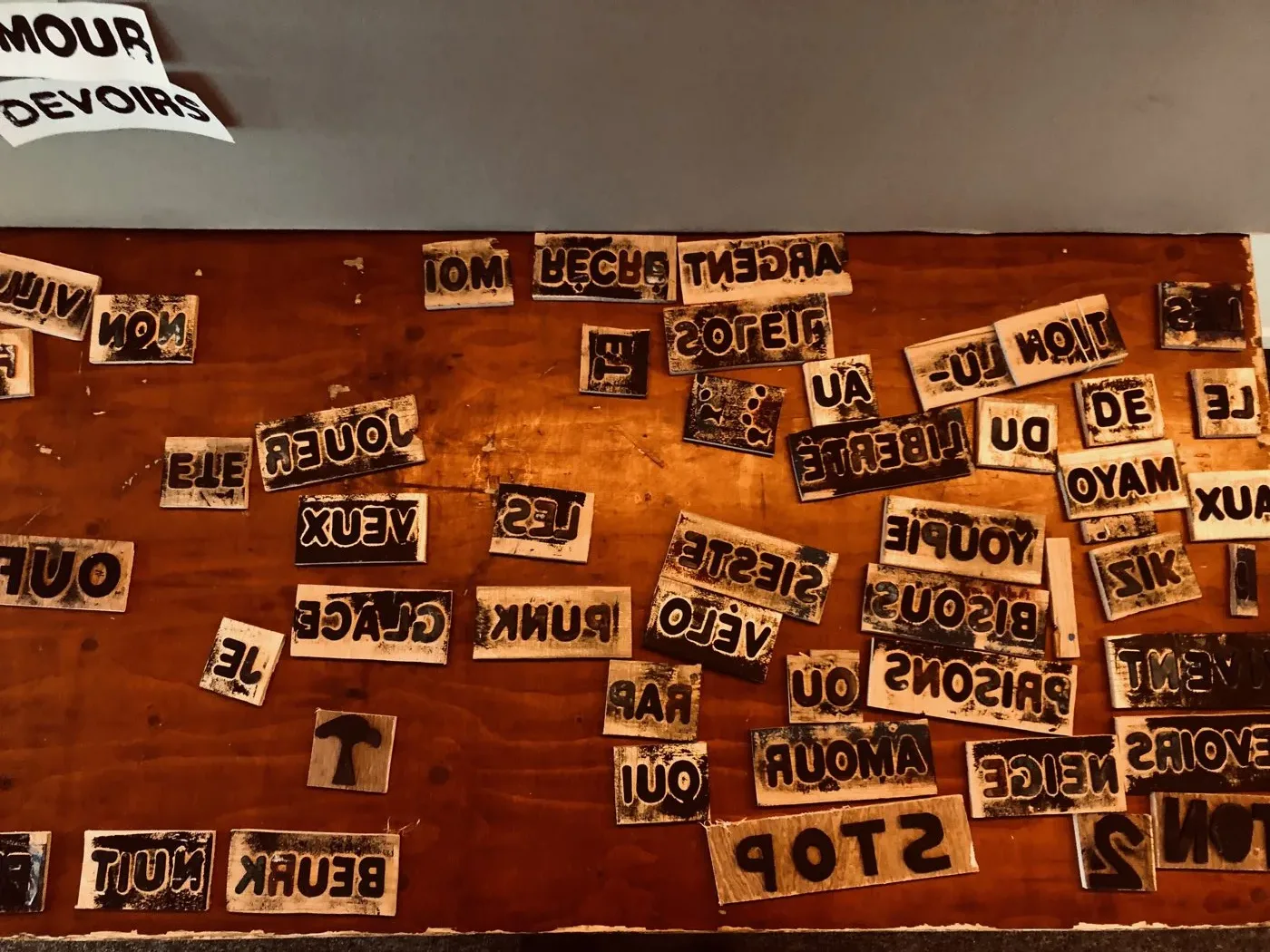 La mosaïque des tuiles de lettres, chacune portant un mot ou un motif