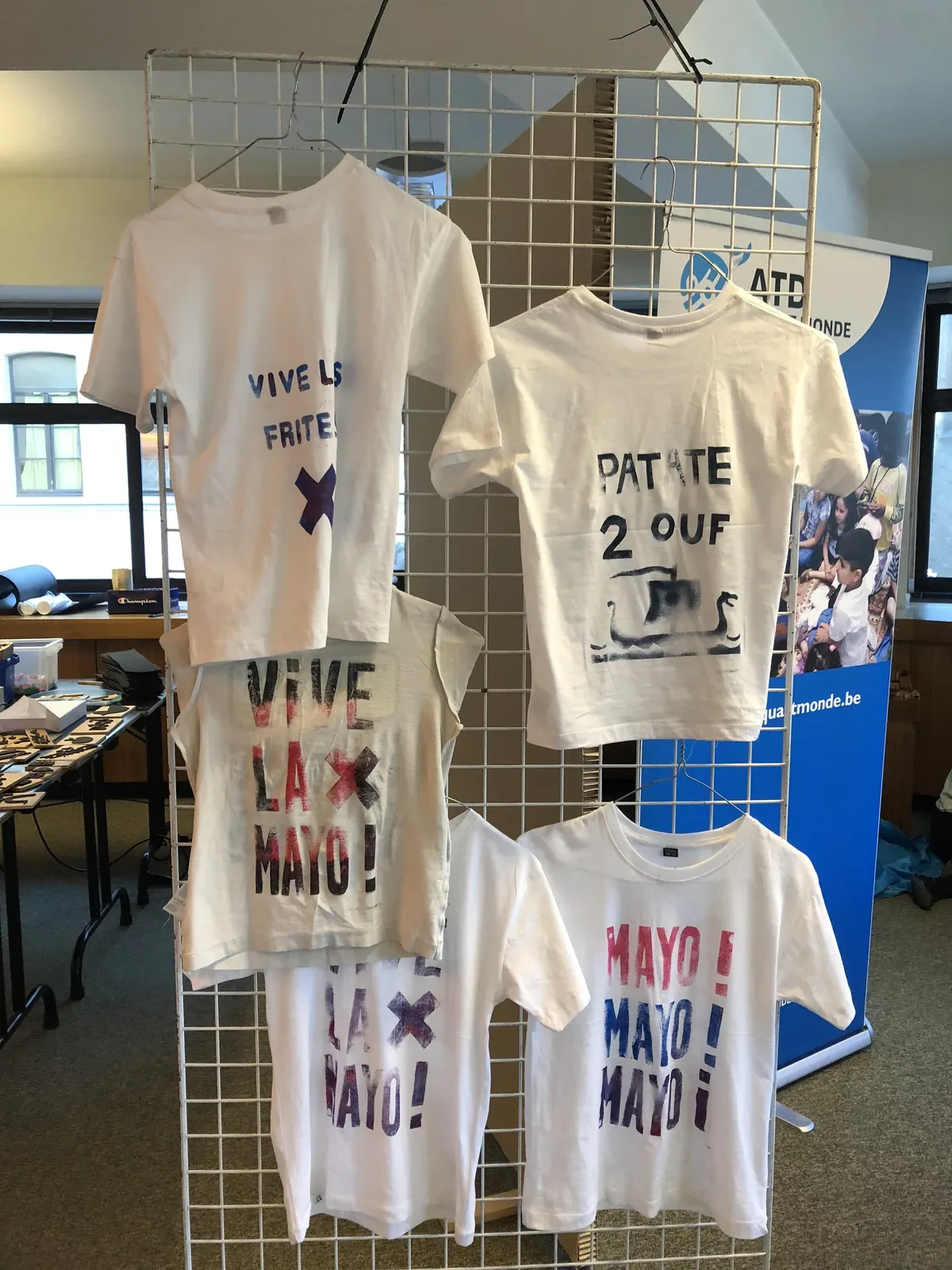 Les t-shirts fraîchement tirés, suspendus à une grille pour sécher