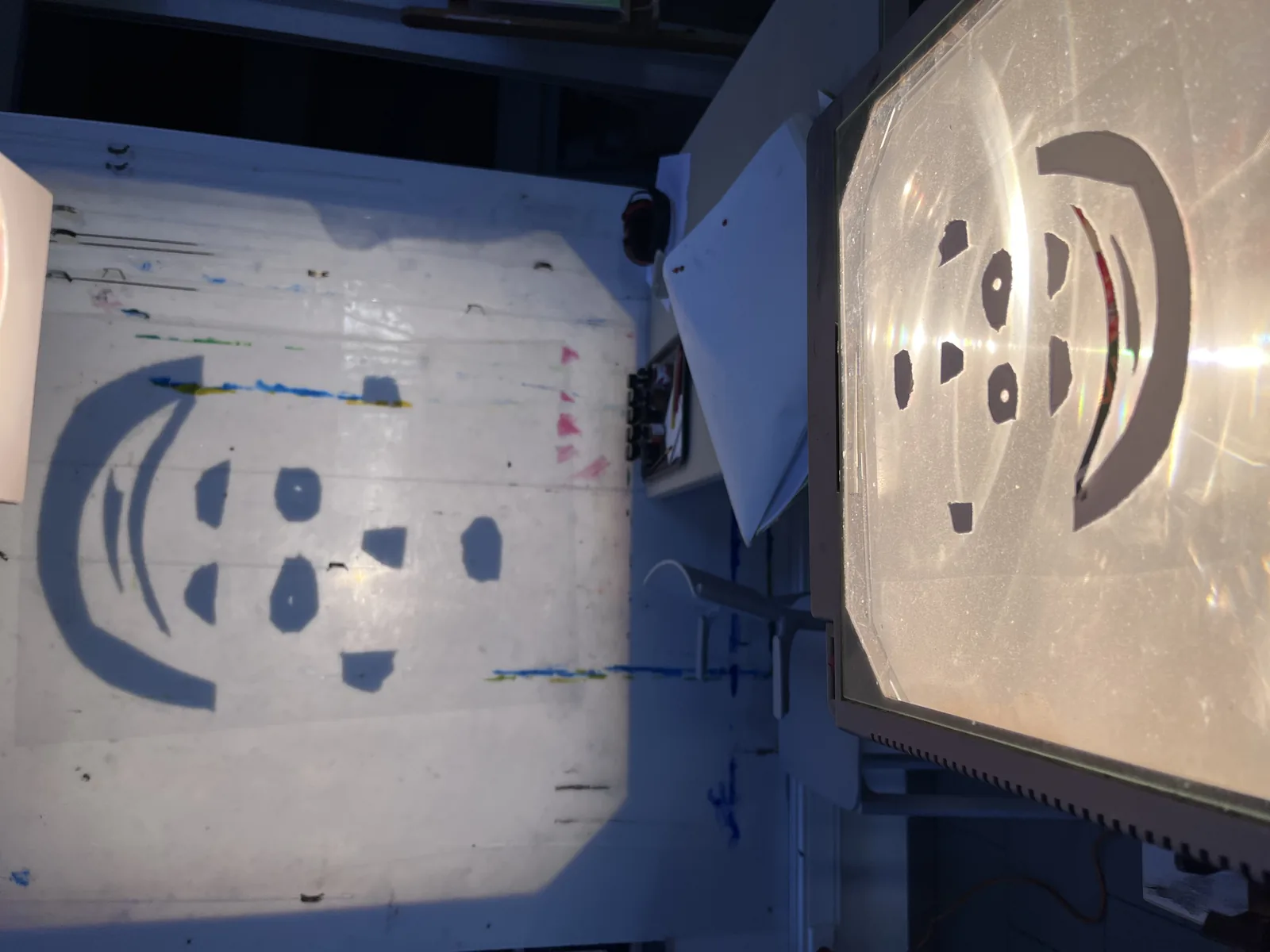 Deux projections côte à côte sur les écrans, deux visages composés de formes découpées