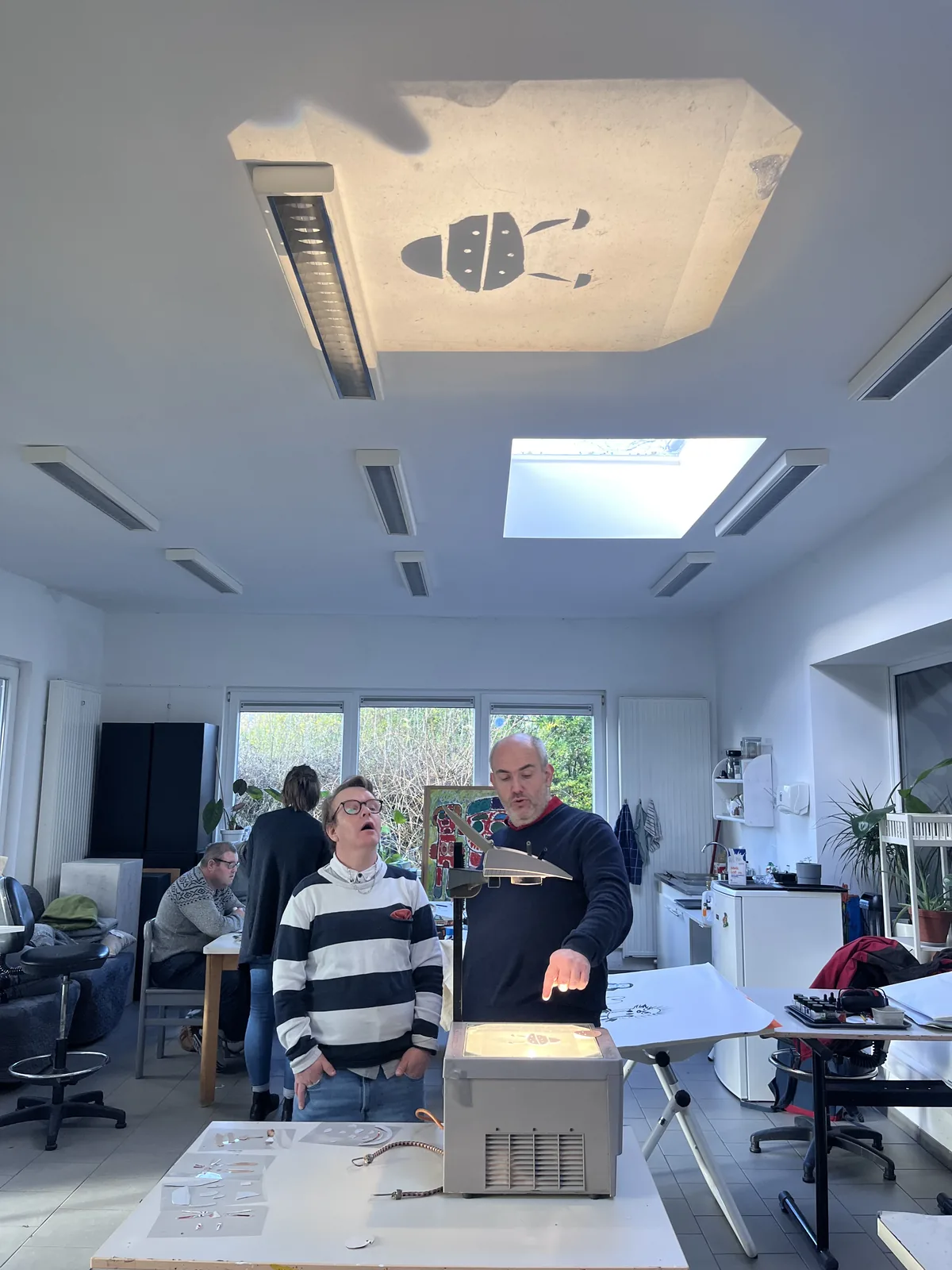 Le rétroprojecteur allumé dans la salle, le faisceau visible jusqu’au plafond